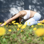 Woman in Child’s Pose Woman practicing child's pose in field of yellow dandelions.